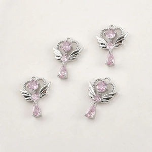 Détail de pendentifs couronne d'ailes d'ange argentés avec cristaux roses en goutte