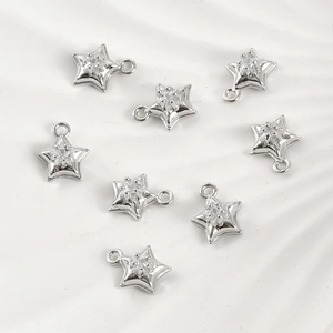 Macro detail of eight silver star pendants with sparkling cubic zirconia for DIY jewelry