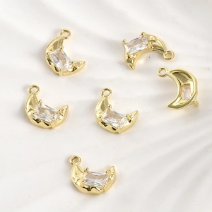 Macro shot of 14k gold-plated crescent moon charms with rectangular zircon for DIY jewelry