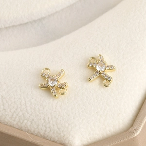 Macro-opname van twee vergulde vliegtuigconnectoren met zirkonia voor DIY-sieraden