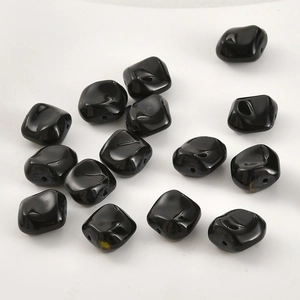 Macro detail of irregular black glazed glass beads for DIY jewelry making and crafts