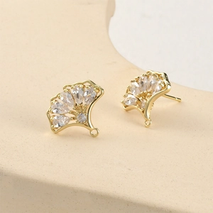 Vue macro de clous d'oreilles feuille de ginkgo dorés 14k sertis de zircons cubiques