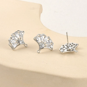 Vue détaillée des boucles d'oreilles ginkgo argentées avec zircon et design évidé