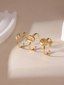 Dettaglio di un set di 3 anelli placcati in oro 18K con motivi di pesci e mare