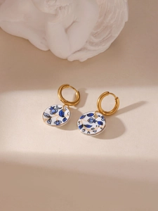 Detail of 18K gold-plated earrings with blue and white porcelain flower ceramic pendant