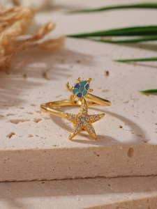 Vista macro dell'anello in oro 18K con stella marina, tartaruga e zirconi scintillanti