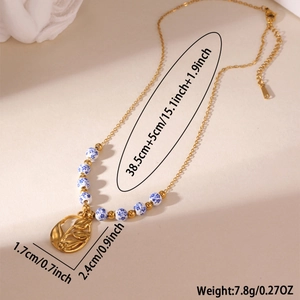 Detail of 18K gold plated necklace with blue and white porcelain beads and tulip charm