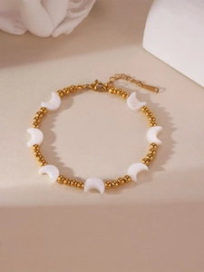 Nahaufnahme des goldenen Perlenarmbands mit weißen Mondanhängern und Karabinerverschluss