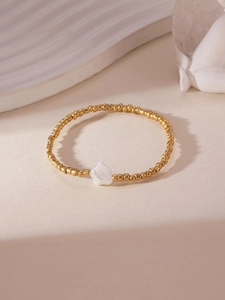 Close-up of 18K gold-plated beaded bracelet with a star-shaped shell charm detail