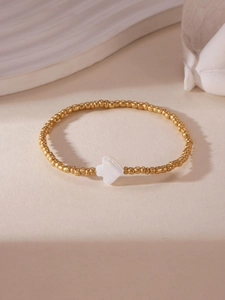 Detailed shot of 18K gold plated beaded bracelet featuring a white shell clover charm