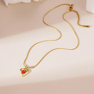 Detail of 18K gold-plated snake chain necklace with strawberry heart pendant