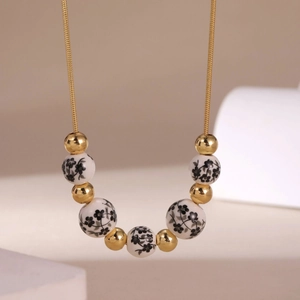 Detail of 18K gold plated chain with blue and white porcelain beads and gold metallic spheres