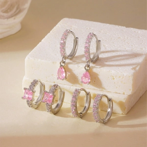 Three pairs of elegant silver earrings set with sparkling pink zircon stones on stone base