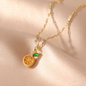 Golden fruit necklace featuring a realistic orange slice pendant on soft silk background