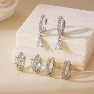 Detailed view of silver hoop earrings with waterdrop and square cubic zirconia on stone base