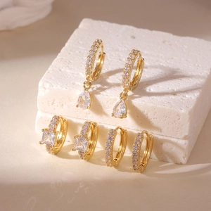 Detailed view of three gold-plated copper hoop earrings with square and teardrop zircons