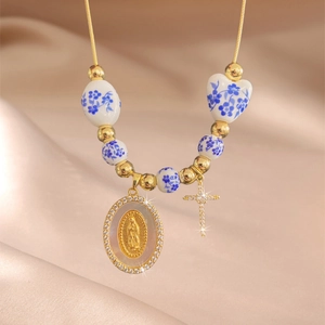 Golden necklace with blue floral ceramic beads and a Virgin Mary relief pendant
