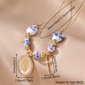 Vintage ceramic necklace with Virgin Mary pendant and gold cross on satin background