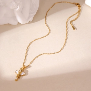 Detail of gold elephant pendant with white enamel ear and evil eye motif on a chain