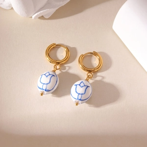 Detailed view of vintage blue and white tulip porcelain beads on golden hoop earrings