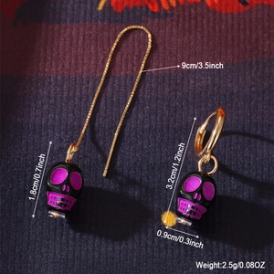 Orecchini teschio asimmetrici per Halloween con smalto viola e catena dorata a filo