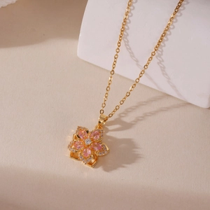 Macro detail of golden flower necklace with pink zircon petals and pavé crystals