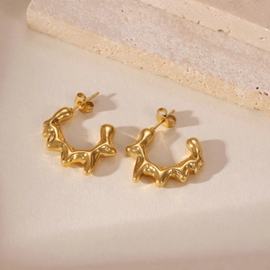 Dettaglio degli orecchini in acciaio placcati oro 18k con trama di metallo liquido