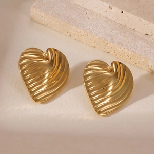 Dettaglio macro di orecchini a cuore placcati oro 18k con motivo a conchiglia vintage