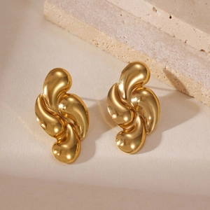 Dettaglio macro di orecchini in acciaio inossidabile placcato oro 18k con trama liquida