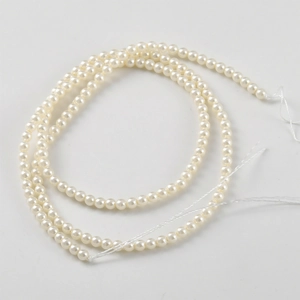 Lustrous round pink synthetic pearls on a strand for DIY jewelry making and crafts