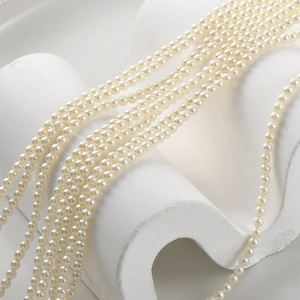 Macro detail of layered creamy white round pearl strands with high luster on artistic stand