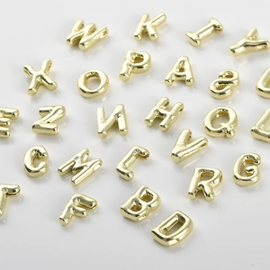 Macro detail of 14k gold-plated 3D capital letter beads for DIY jewelry making accessories