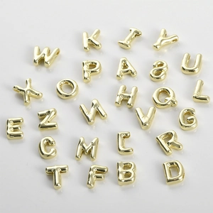 Macro view of 14k gold-plated 3D bubble style alphabet letter beads for DIY jewelry making