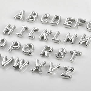 Macro shot of 26 3D glossy silver alphabet beads with side holes for DIY jewelry
