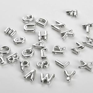 Macro view of silver alphabet beads for DIY jewelry with high metallic luster