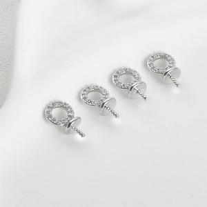 Close-up of four 14k gold-plated silver pendant caps with cubic zirconia for jewelry making