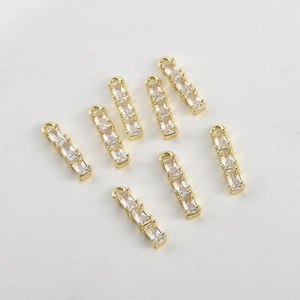 Macro view of seven 14k gold plated bamboo-shaped pendants with gradient cubic zirconia