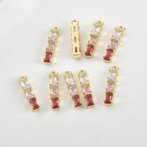 Macro view of 14k gold-plated bamboo pendants with gradient pink zircon crystals