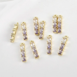 Macro detail of 14k gold-plated bamboo pendants with purple gradient zircon stones