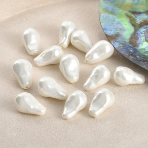 Close-up of white teardrop baroque imitation pearls with iridescent luster for DIY jewelry