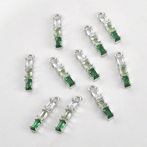 Macro view of 14k gold-plated bamboo-style pendants with gradient green zircon gems
