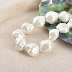 Detailed macro view of irregular baroque pearl beads with glossy texture and white finish