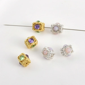 Dettaglio di perle rettangolari filigranate in oro e argento con pietre preziose colorate
