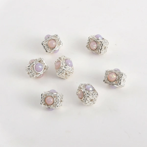 Vista macro di charms cubici in argento con opali viola e incisioni decorative fini
