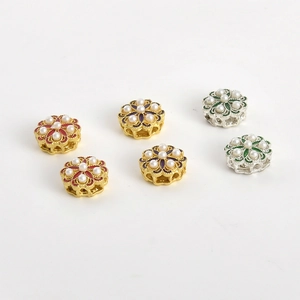 Dettaglio di perline distanziatrici a fiore vintage con perle e smalto per gioielli fai-da-te