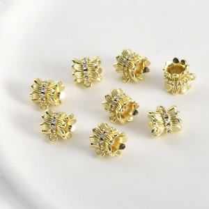 Close-up of 14k gold-filled barrel beads with zircon inlay and hanging loops for DIY jewelry