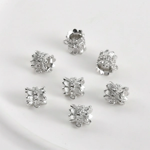 Macro shot of 7 silver floral spacer beads with sparkling zircon stones for jewelry DIY