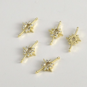 Macro detail of 14k gold-plated starburst charms with zircon stones for DIY jewelry