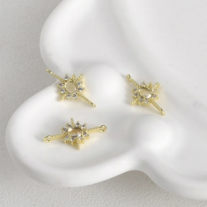 Macro detail of 14k gold-plated starburst charms with cubic zirconia for DIY jewelry