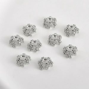 Detalle de nueve cuentas espaciadoras plateadas en forma de estrella para joyería DIY